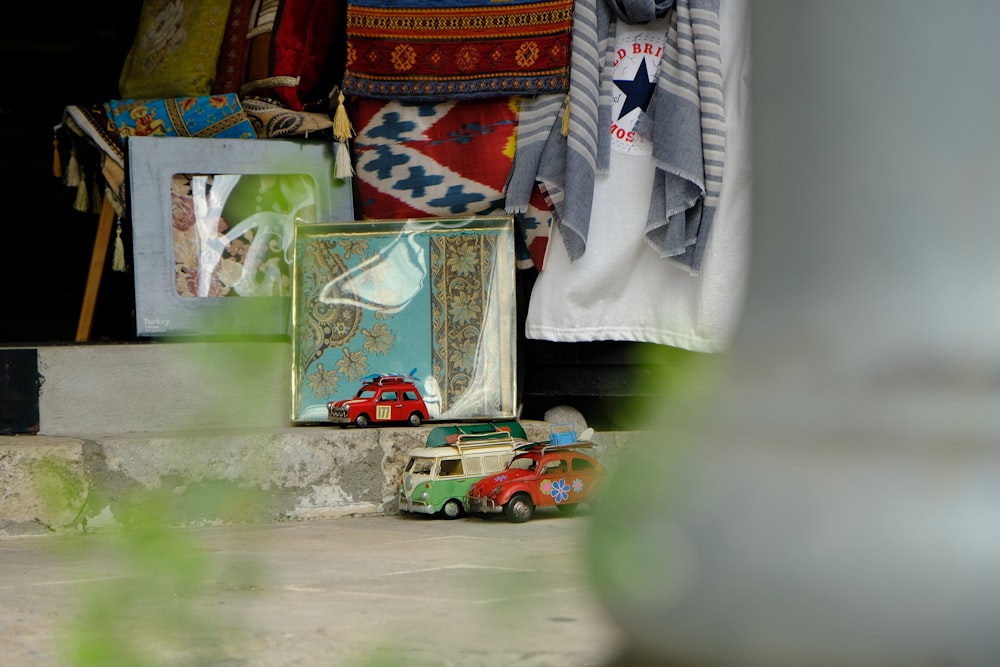 red Volkswagen Beetle and teal Volkswagne T1 scale models on gray concrete floor