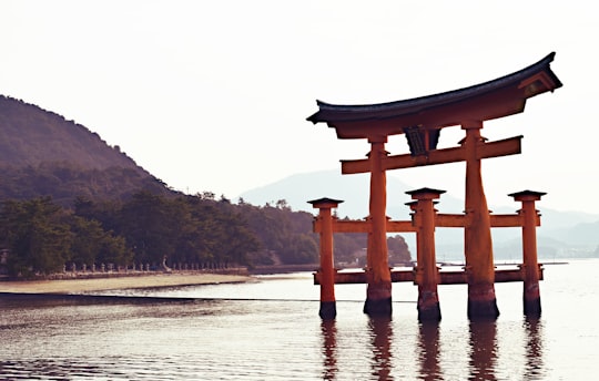 tower on body of water in Itsukushima Shrine Japan