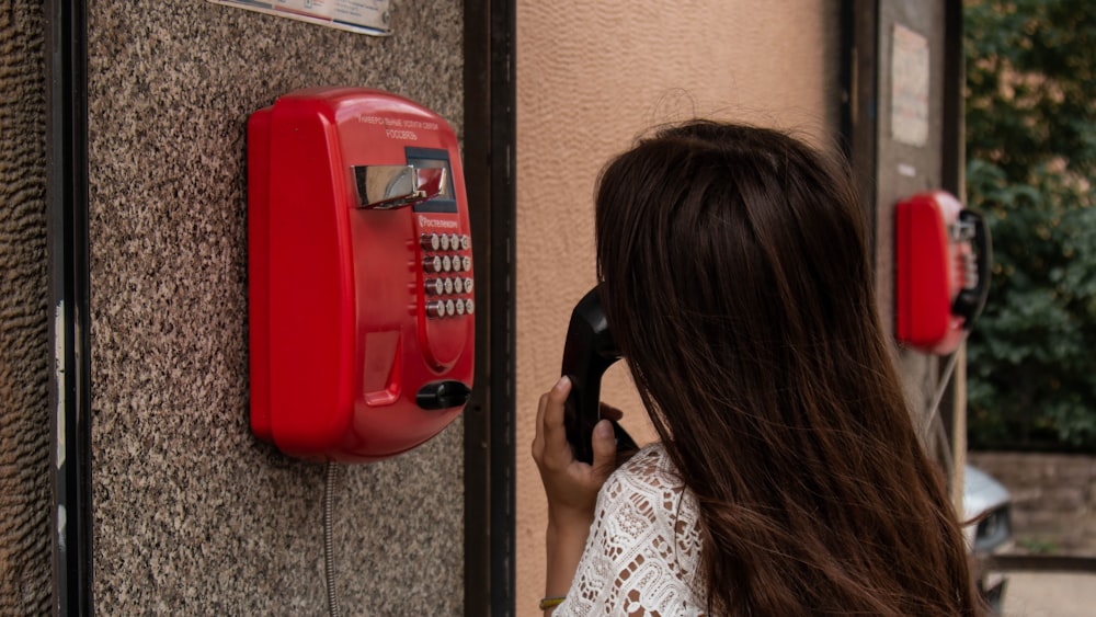 Mujer usando teléfono público