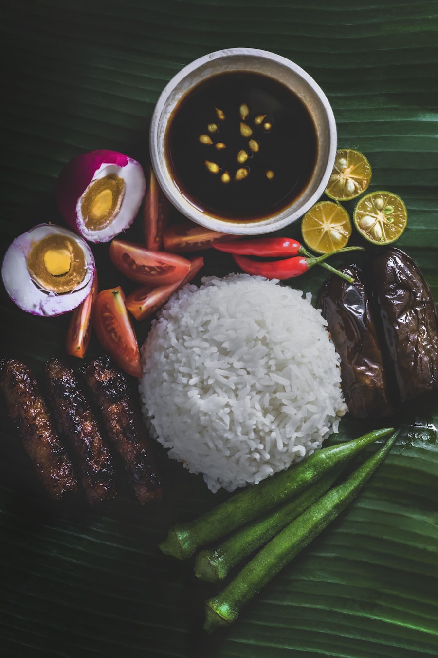 Filipino home-style spread on a banana leaf — rice, longganisa, salted egg and calamansi