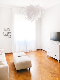 Bright, elegant living room with modern furniture and natural light highlighting a pristine, spotless interior.