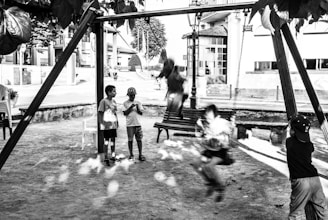 Children playing on swings and slides under bright sunny skies.