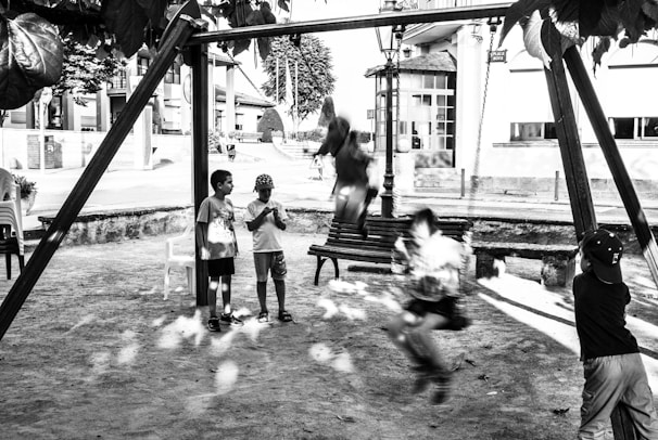Children playing together on a playground swing.