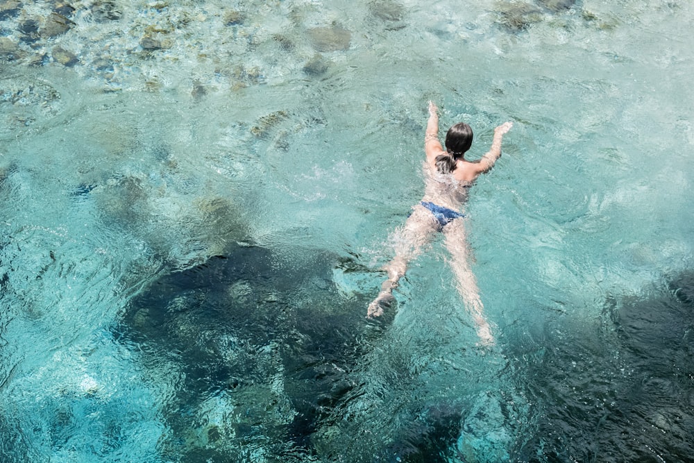 mujer nadando en cuerpo de agua