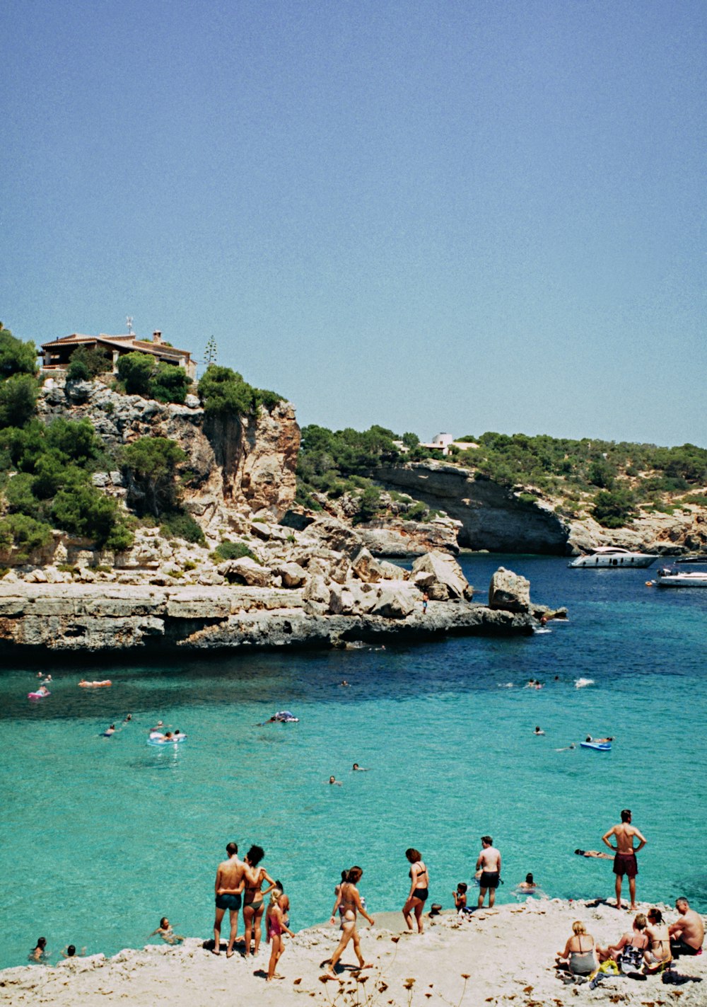 people near body of water under blue sky