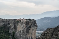 A quiet monastery perched on a rugged hillside under soft morning light.