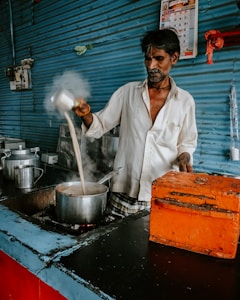 man pouring sauce on pot