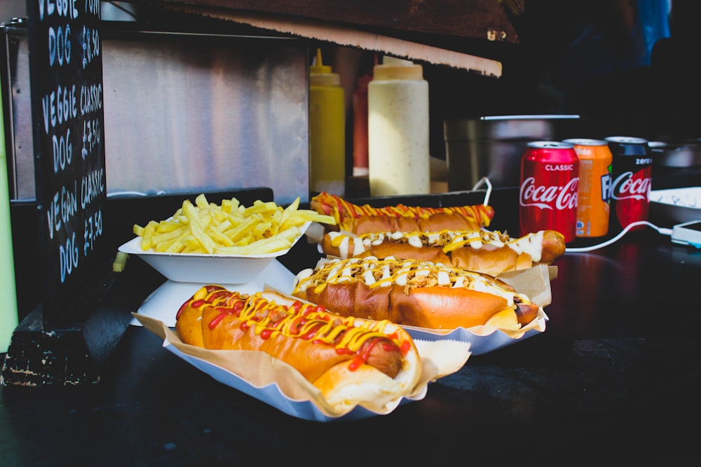 four hotdog sandwiches on desk