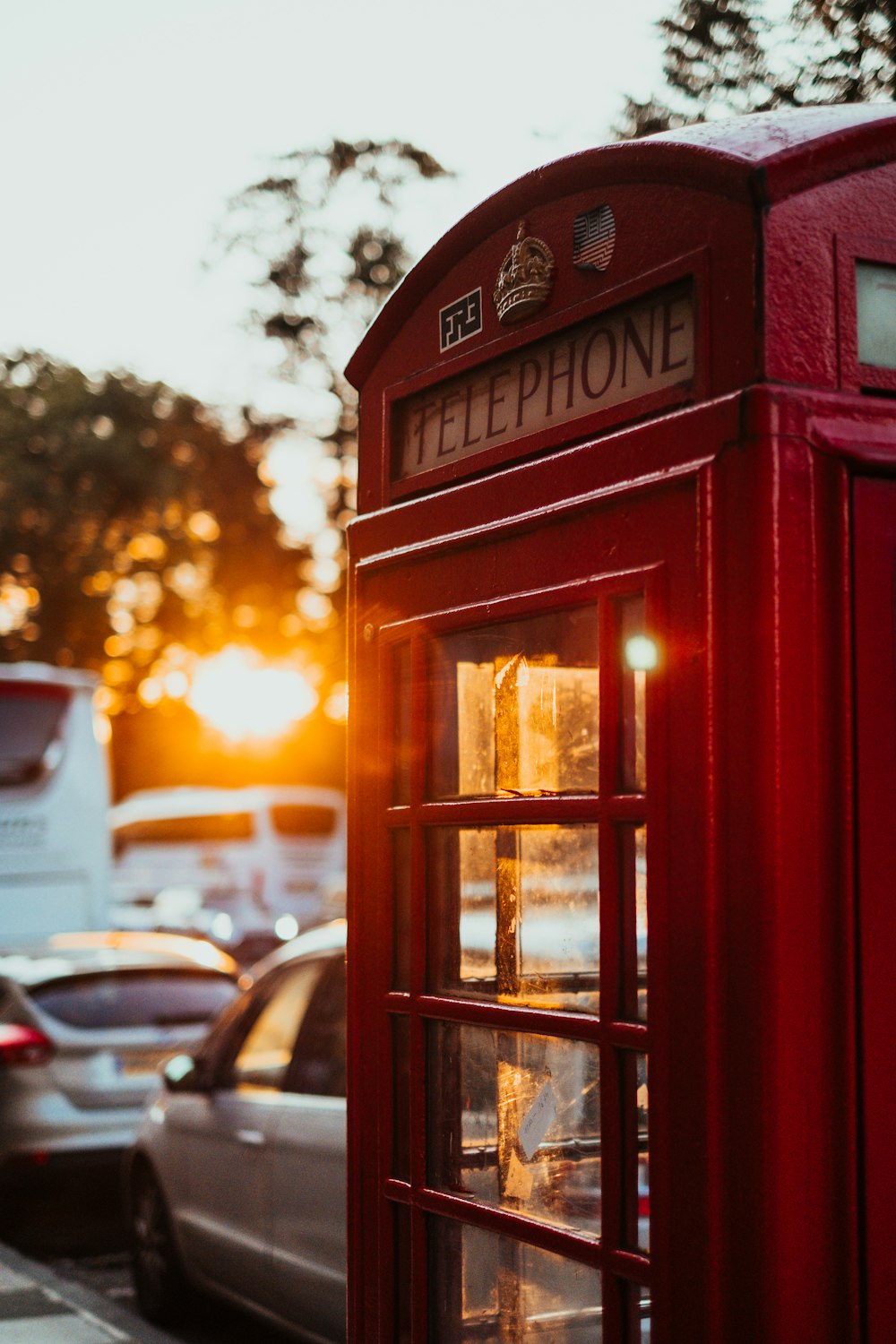 Selektive Fokusfotografie der roten Telefonzelle in der Nähe des Autos