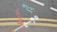 Road markings on asphalt include double yellow lines, indicating no parking restrictions, and several colored spray paint markings in red, white, cyan, and orange, possibly denoting utility lines or underground work.