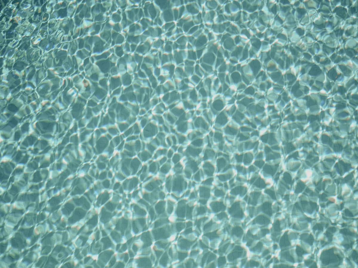 Crystal clear pool water on a sunny day, the result of properly functioning pump and filtration equipment