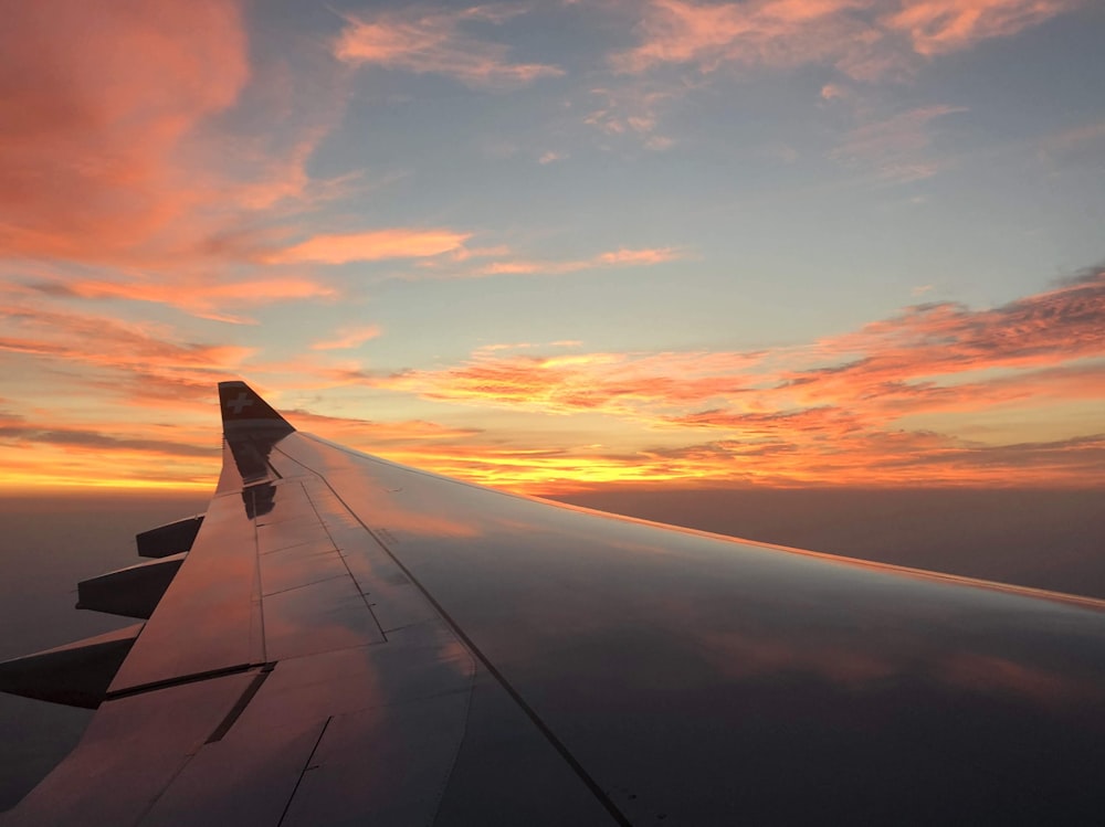 Aeronave cinza voando durante o pôr do sol laranja