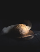 baked bread beside knife on wooden board