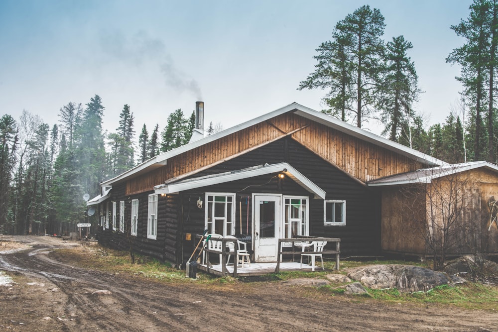 black and brown wooden house beside mud road