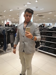 A stylish person trying on different outfits in front of a mirror.