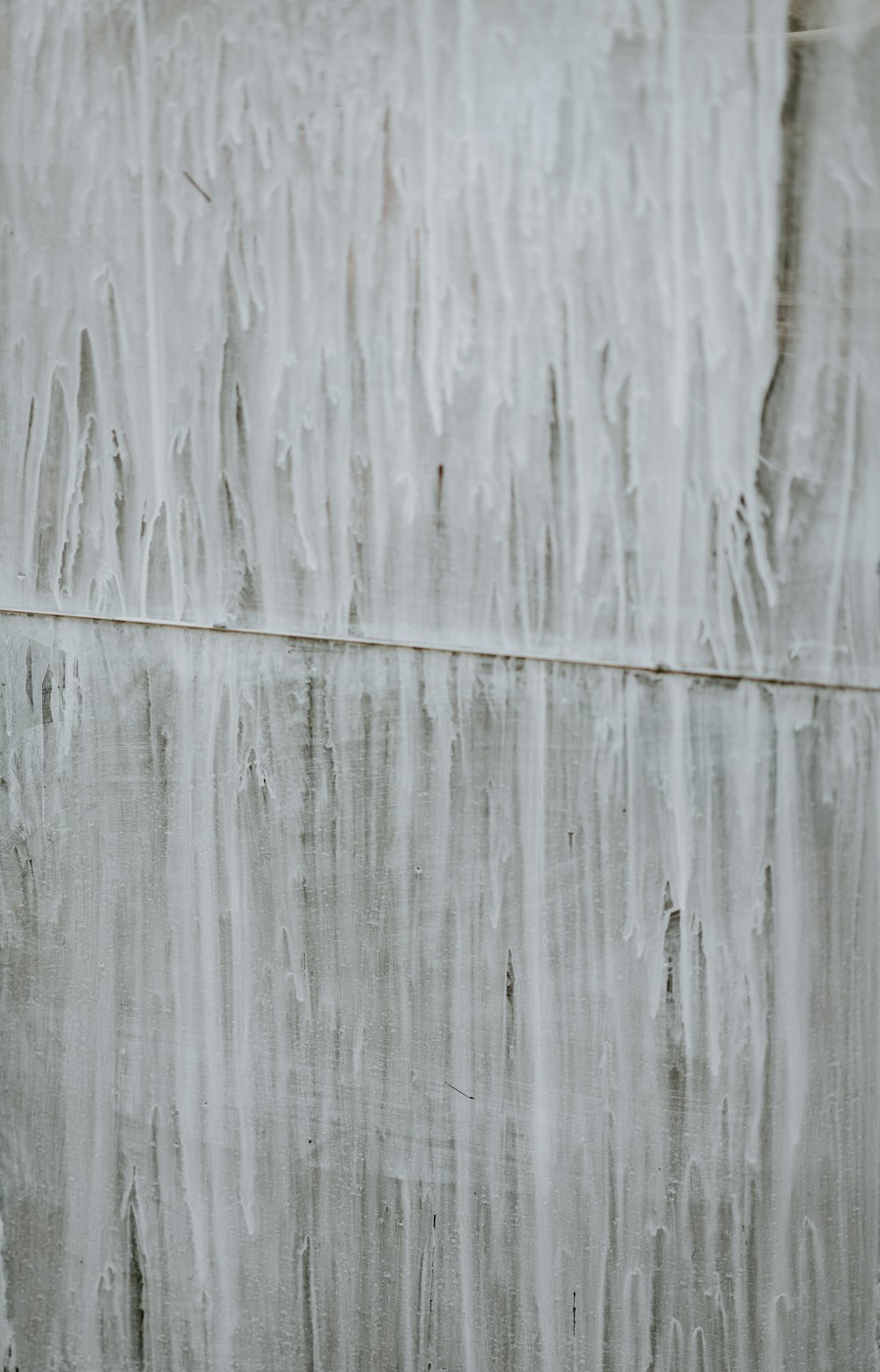 a red fire hydrant sitting in front of a wall covered in ice