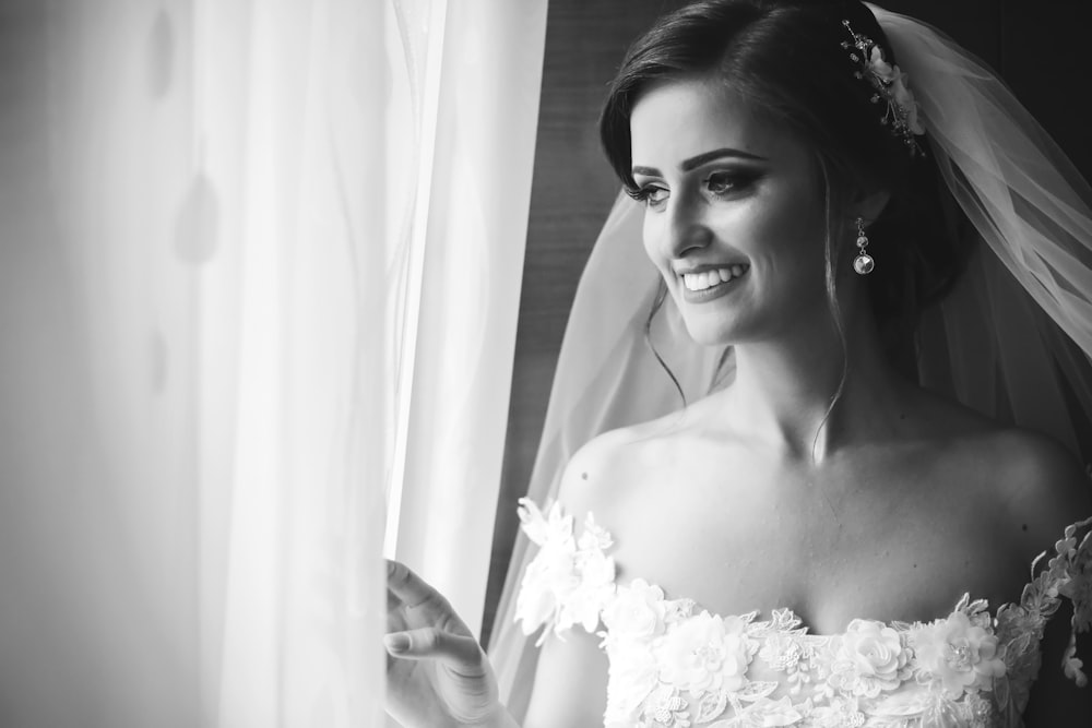 Photo en niveaux de gris d’une femme en robe de mariée