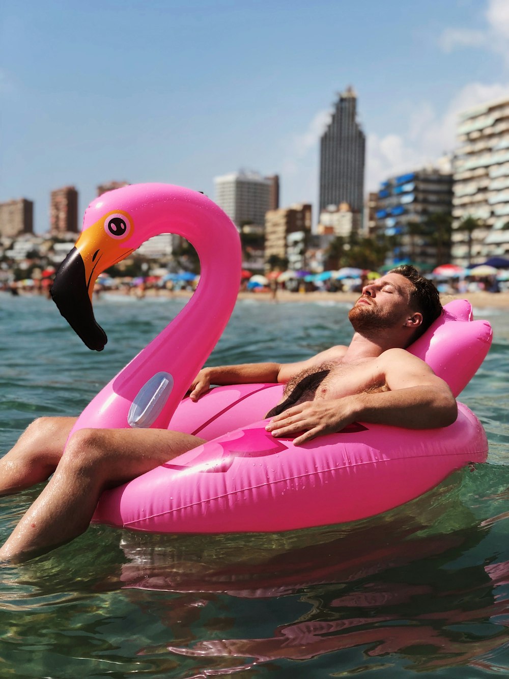 man lying on flamingo buoy