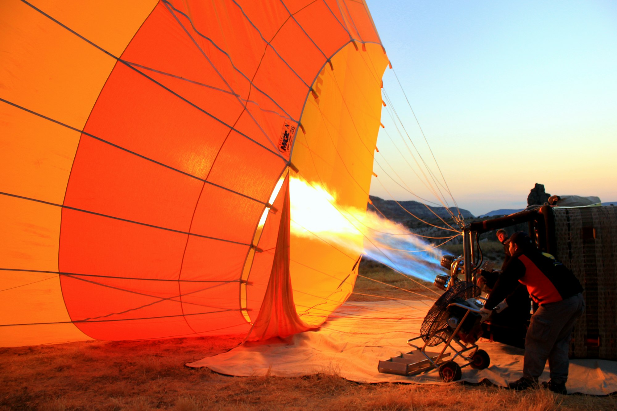 The pilot is preparing its balloon to take off.