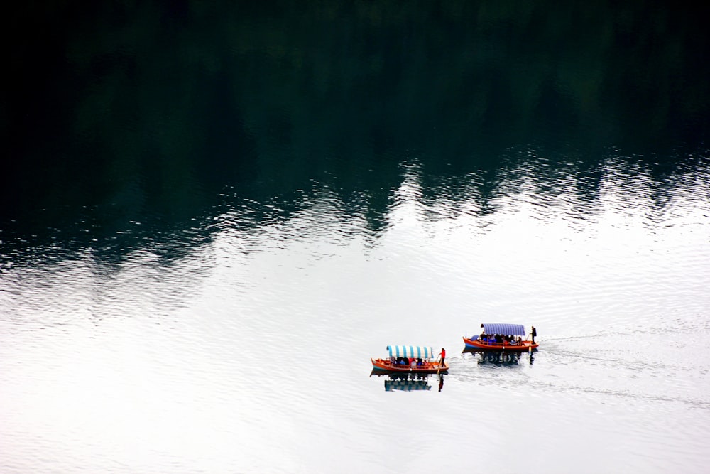 people on two boats on lake