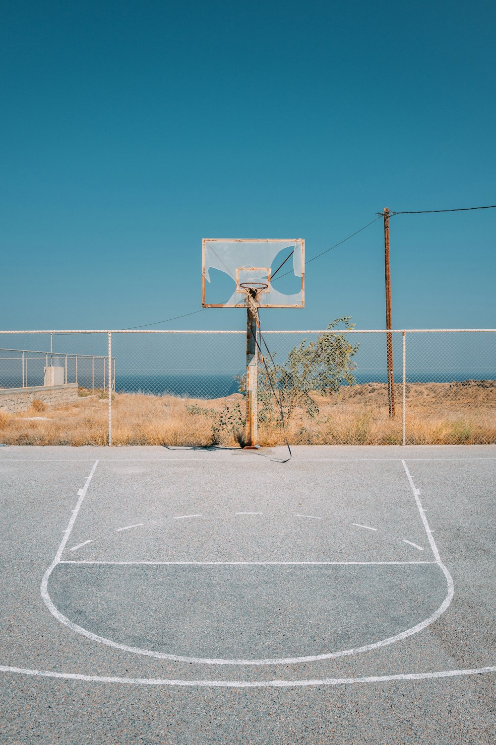 gray basketball field near body of water