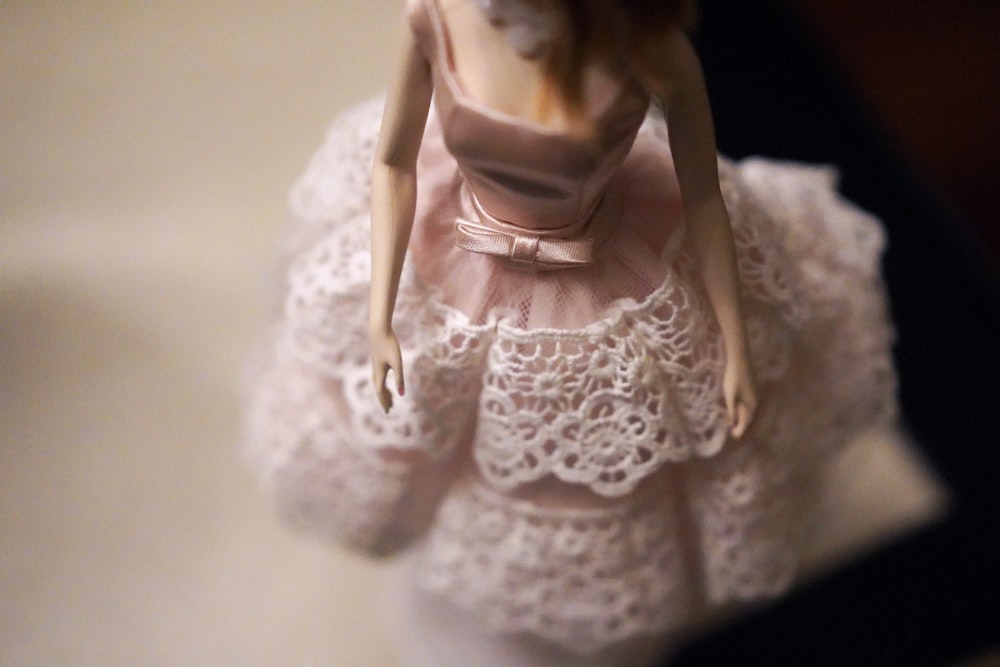 primo piano della bambola femminile che indossa un vestito rosa e bianco