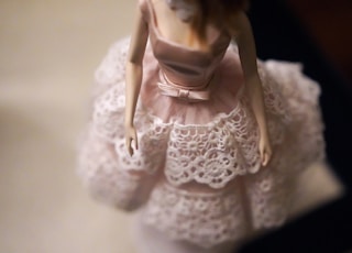 close-up of female doll wearing pink and white dress