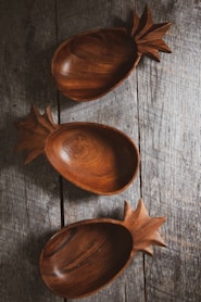 three brown wooden bowls on gray wood