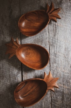 three brown wooden bowls on gray wood