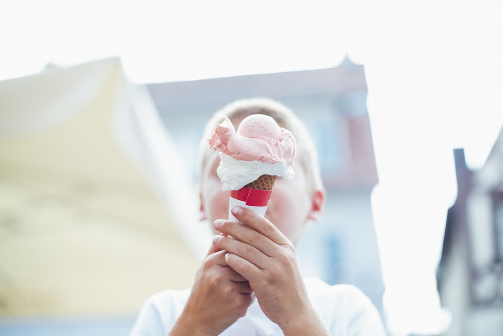 garçon tenant de la crème glacée avec un cône