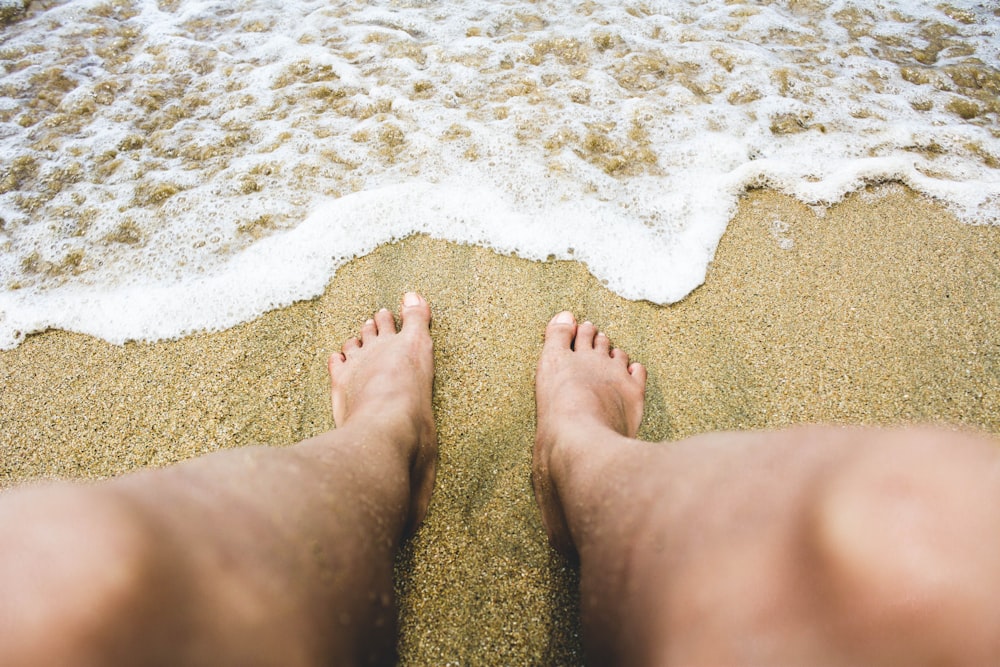 person sitting on seashore during daytime