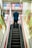 man in blue suit jacket standing on escalator