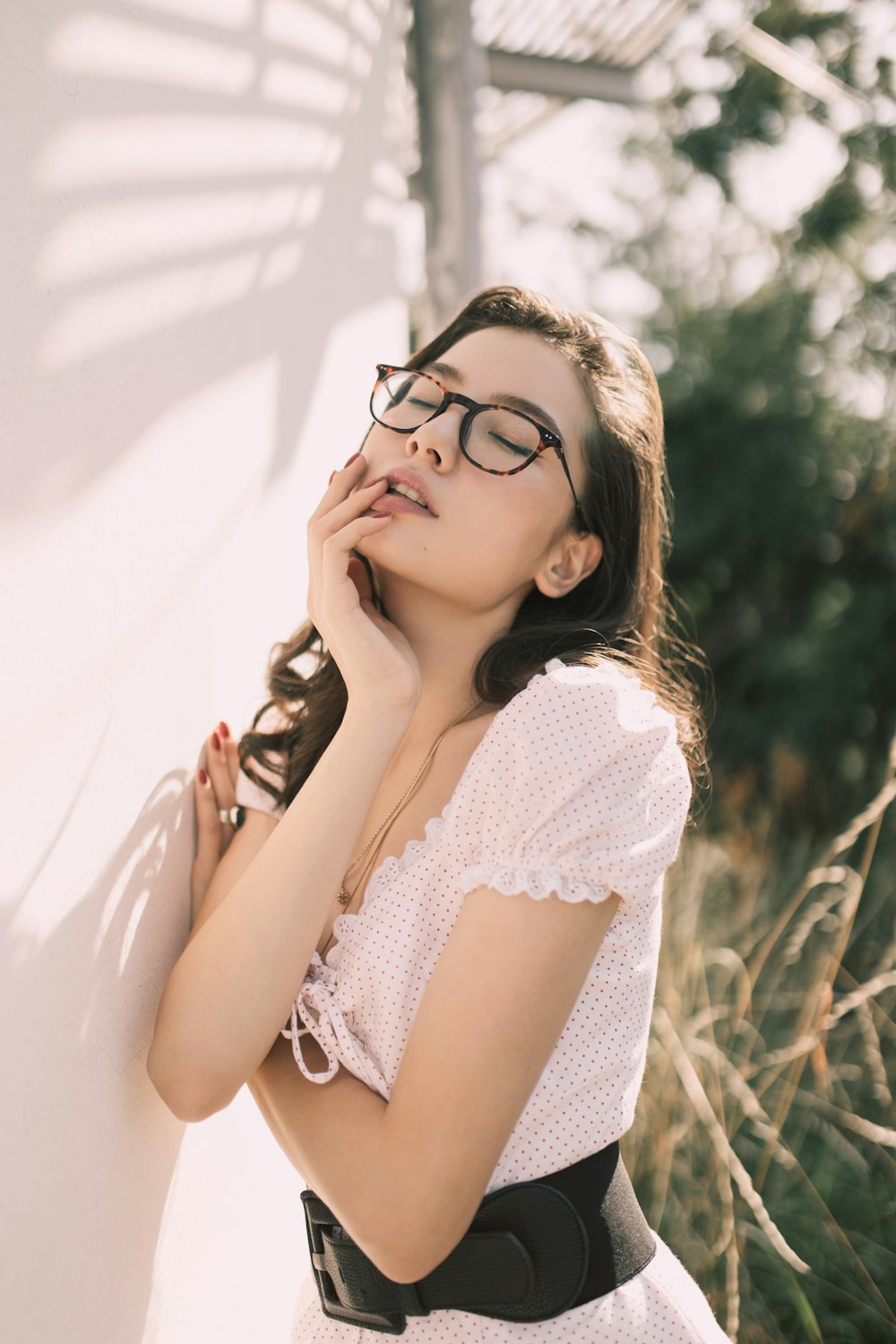 woman in white and black top wearing eyeglasses