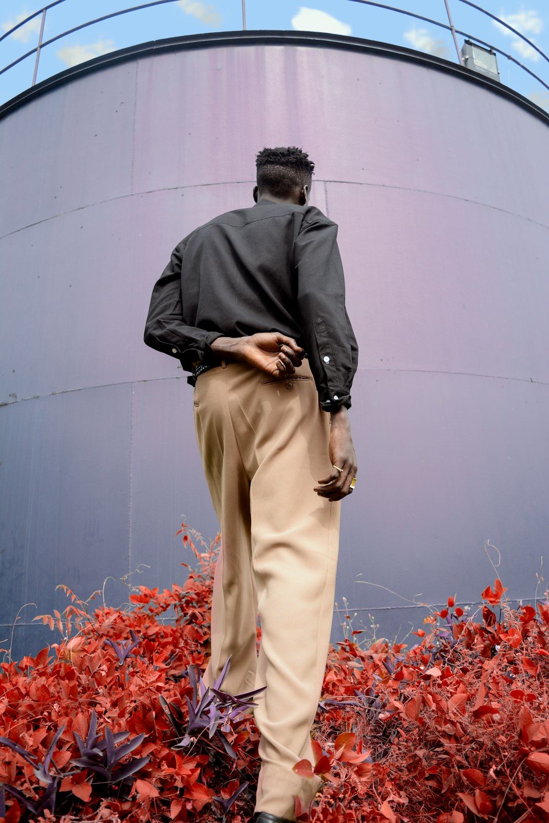 man standing facing tank