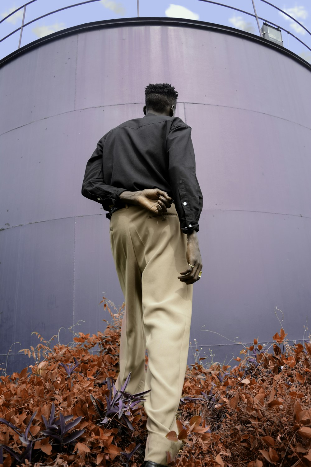 man standing facing tank