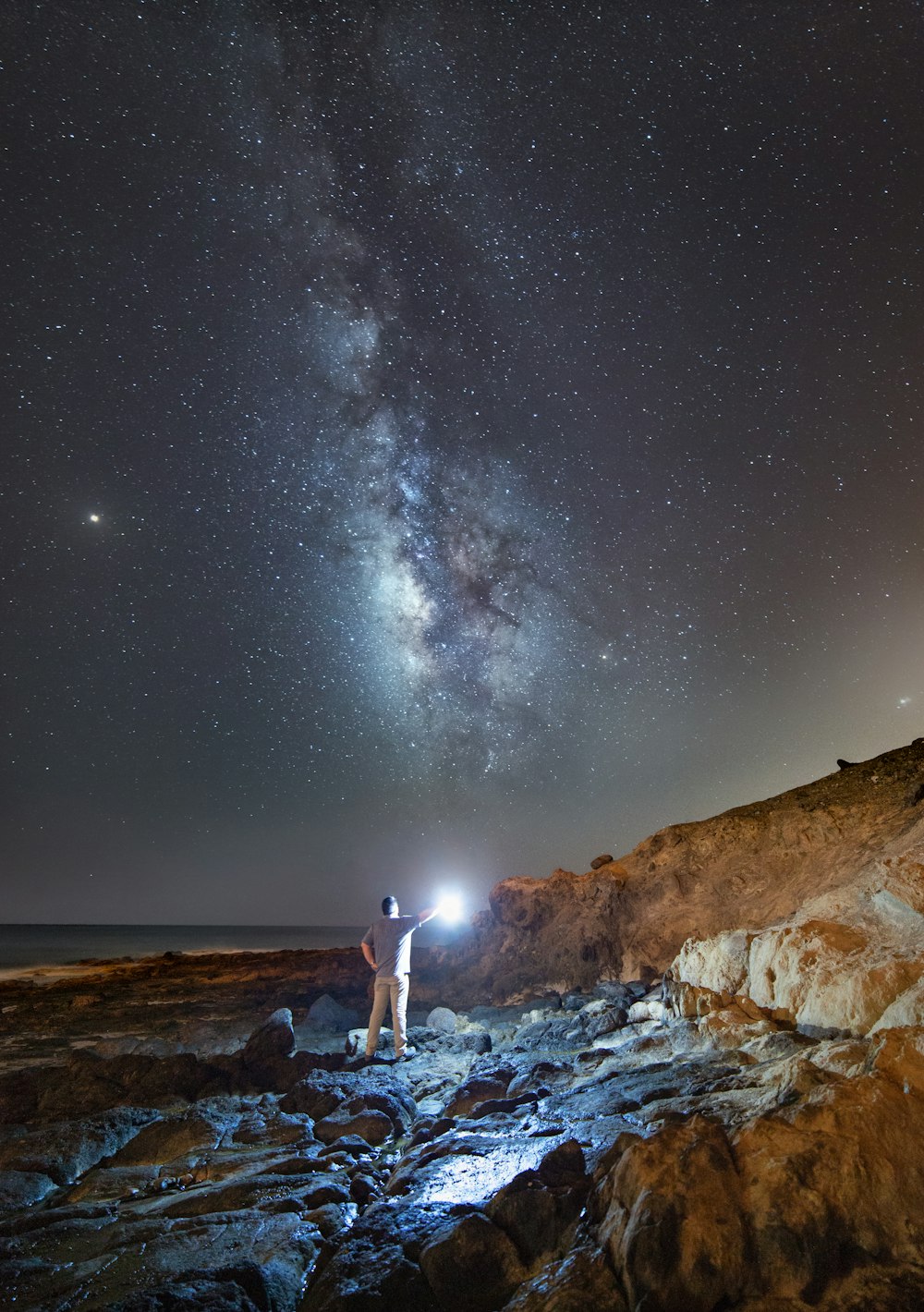 man holding light under night sky
