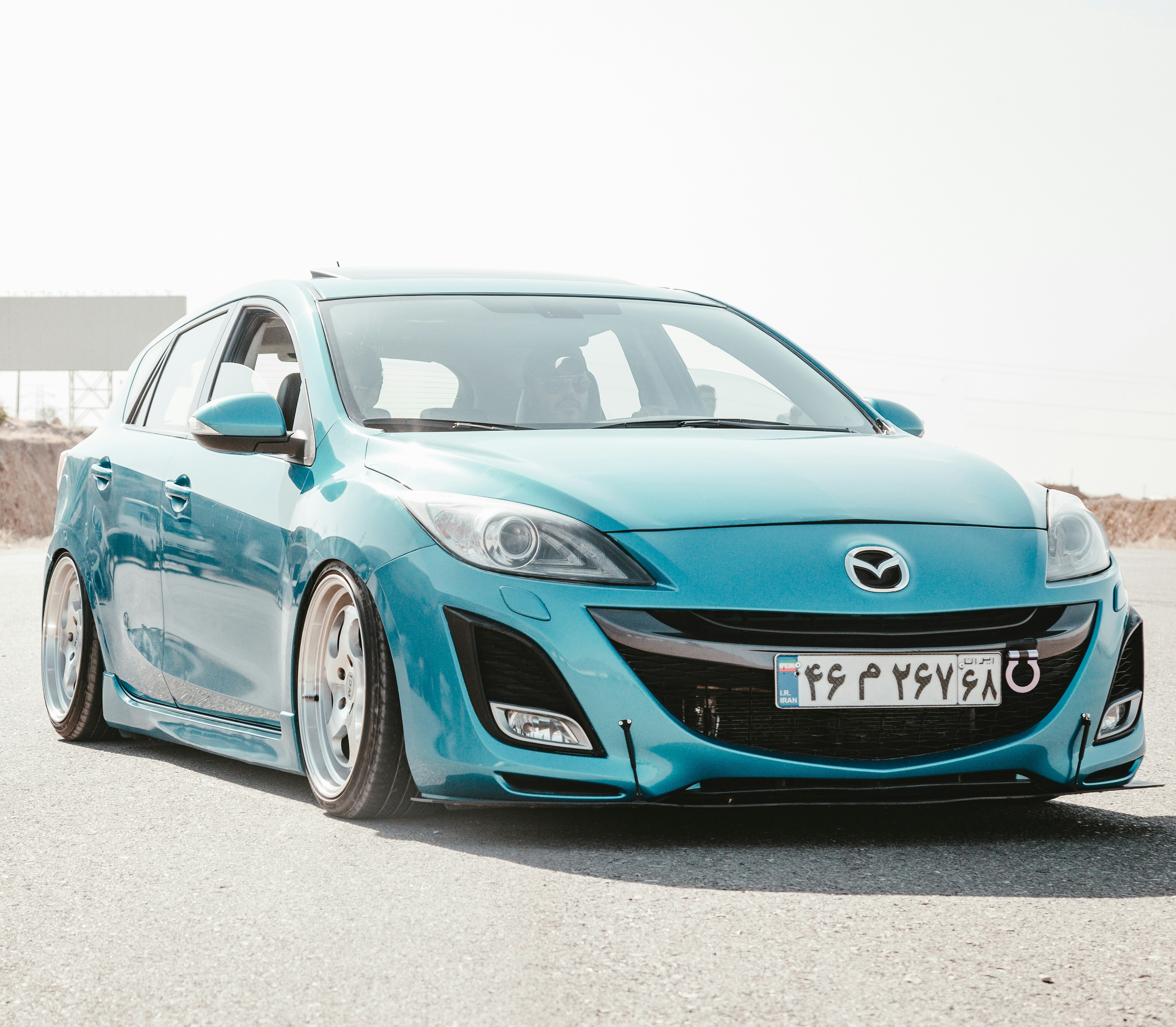 blue Mazda 3 5-door hatchback on ground