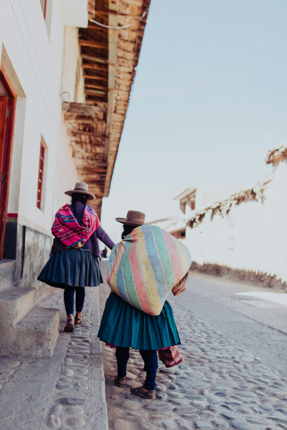 two person carrying bags standing on gray concrete floor