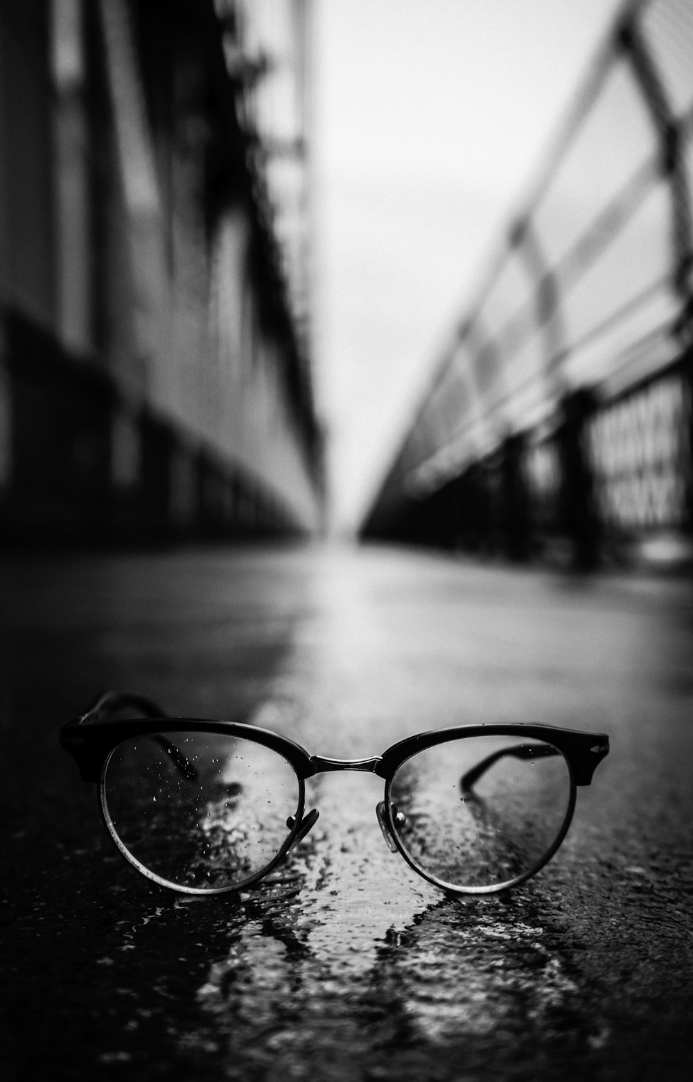 fotografia in scala di grigi di occhiali da sole in stile Clubmaster su strada