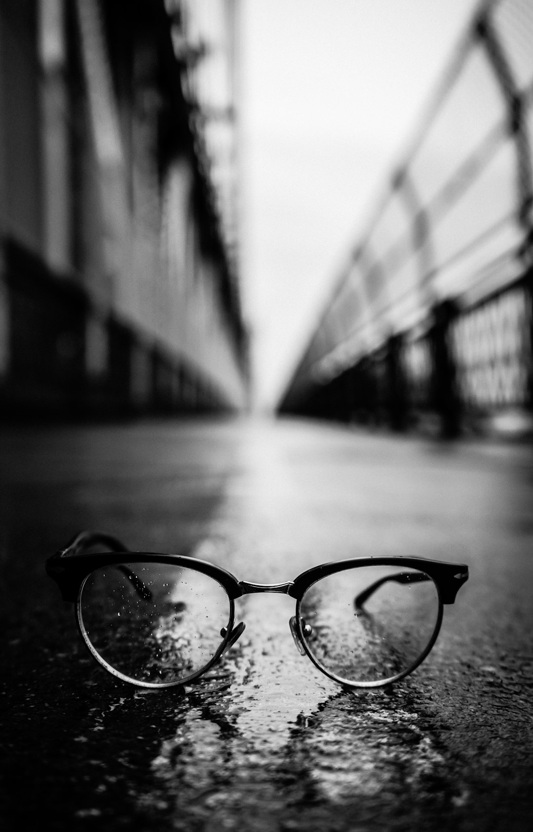 gray scale photography of Clubmaster-style sunglasses on road