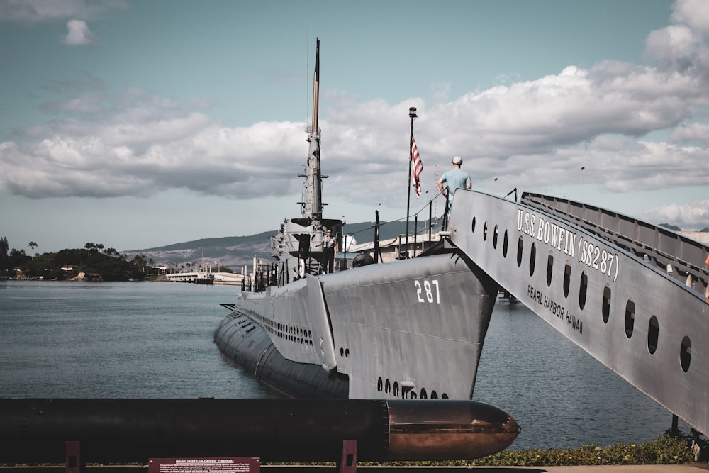 grey warship on dock during daytime
