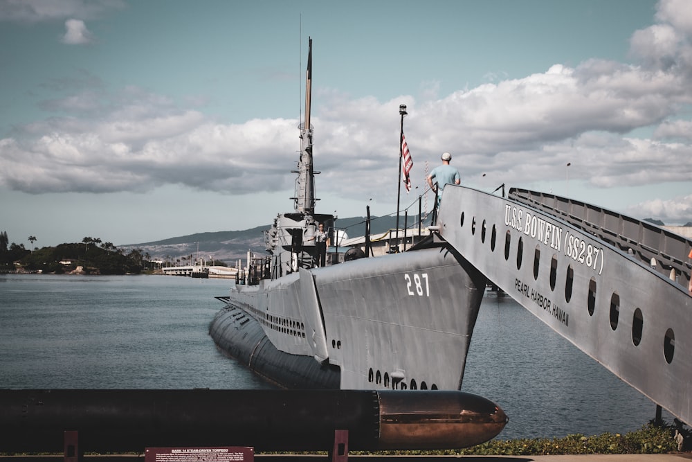 Graues Kriegsschiff tagsüber am Dock