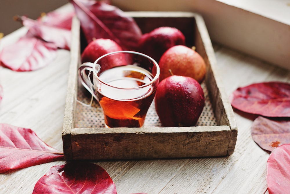 clear glass tea cup in brown wooden tray