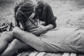 A soft black and pink blanket draped over a couple’s lap as they share a quiet moment.