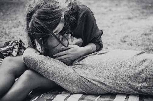 An intimate black and white shot of a family playing in a sunlit park.