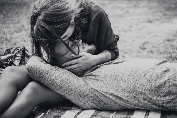 A soft black and pink blanket draped over a couple’s lap as they share a quiet moment.