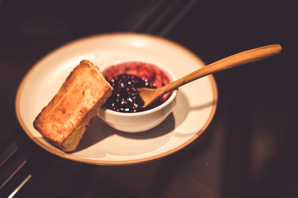 blueberry jam in bowl with spoon and slice of bread