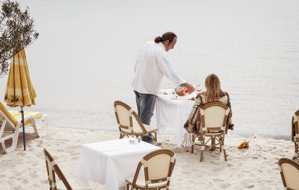 man and woman having meal at the shore
