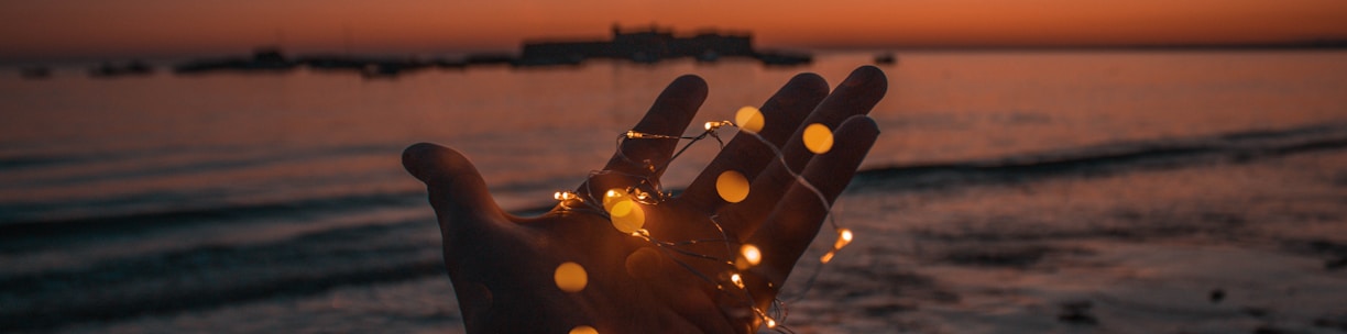 person with string lights on left hand