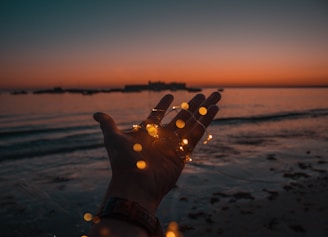 person with string lights on left hand